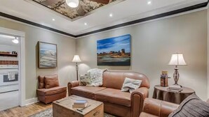 Uma sala de estar com sofá, mesa de centro e luminárias.