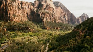 Un paisaje montañoso con un sendero serpenteante y vegetación escasa.