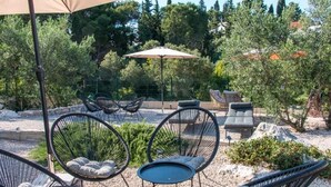 Outdoor seating with chairs and tables, surrounded by trees and a fence. - Two bedroom apartment with garden (Trpanj)