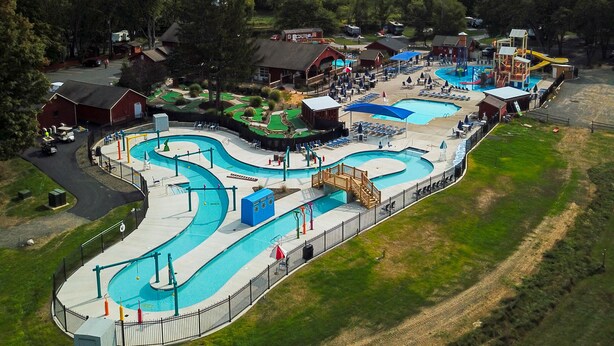 A water park with multiple swimming pools, a covered area, and a playground.