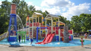 A water park with a water slide, play structures, and a pool.