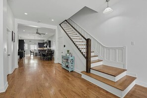 A modern interior with a wooden staircase, a dining area, and a kitchen. - Bronzeville Executive Retreat (Chicago)