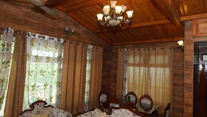 A room with wooden ceiling beams, a chandelier, floral curtains, and antique-style furniture. - 2-Bedroom Self-Contained Accommodation with Entire Private Floor (Doom Gaon)