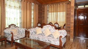 A room with two sofas, a glass coffee table, wooden walls, and a wooden door. - 2-Bedroom Self-Contained Accommodation with Entire Private Floor (Doom Gaon)