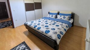 A bedroom with a bed, a wardrobe, and a radiator. - Peaceful & Cozy Apartment Gostivar (Gostivar)