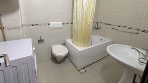 A bathroom with a toilet, bathtub, and sink. - Peaceful & Cozy Apartment Gostivar (Gostivar)