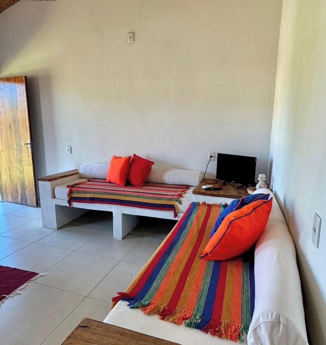 Una habitación moderna con dos sofás, un televisor y una mesa de madera.