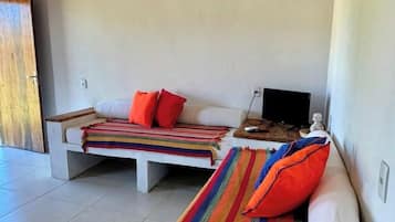 Una habitación moderna con dos sofás, un televisor y una mesa de madera.