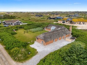 A rural house with a thatched roof, surrounded by greenery and a gravel driveway. - "Janne" -  from the sea by Interhome (Ringkøbing)
