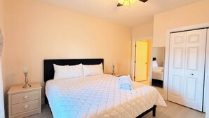 Una camera da letto con un letto, comodino, lampada e armadio.