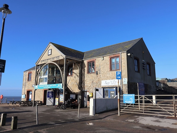 Un edificio con un cartel que dice 'Charming Heritage Coast Centre' y un cartel que anuncia 'Sea Lily'.