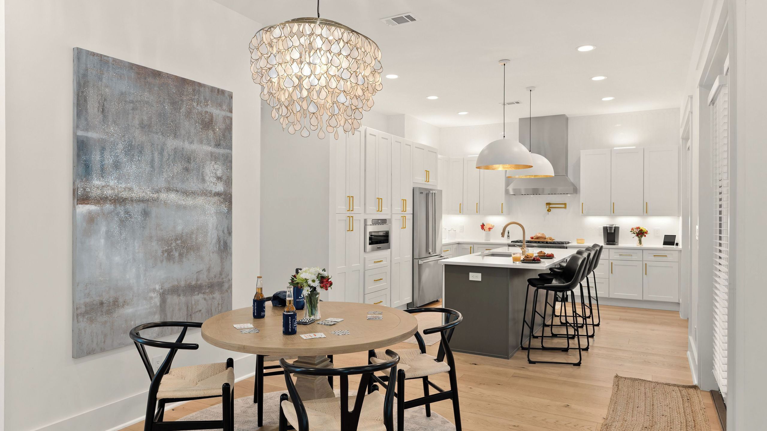 A modern kitchen with white cabinetry, a central island, and pendant lighting.