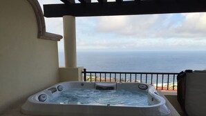 Boblebad på en balkon med udsigt over havet.