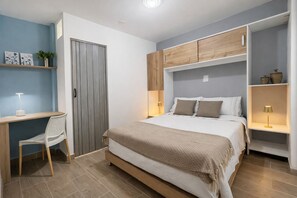A bedroom with a bed, bedside tables, a desk, and a chair. - Authentic Casa Paisa with a Private Patio and Outdoor Kitchen in Medellín (Medellín)