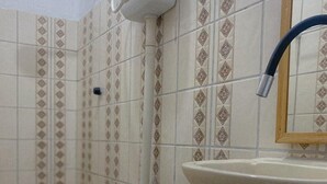 Un baño con inodoro, lavabo y paredes con azulejos.