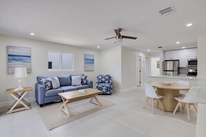 Ein modernes Wohnzimmer mit einer Couch, einem Couchtisch und einem Essbereich mit Stühlen.