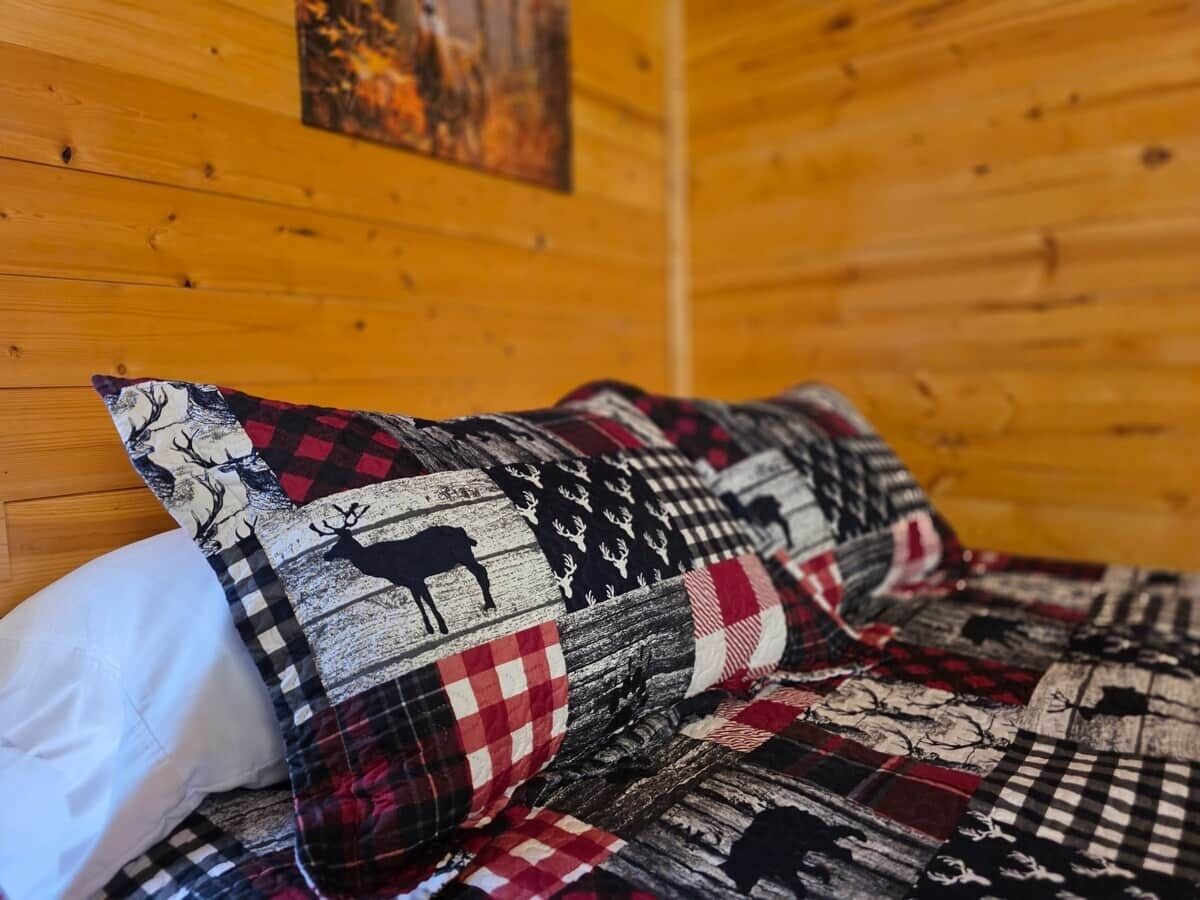 A bed with a checkered blanket featuring animal prints.
