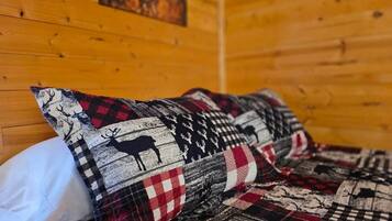 A bed with a checkered blanket featuring animal prints.