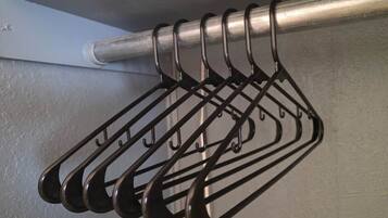 A metal rack with multiple hooks against a wall.