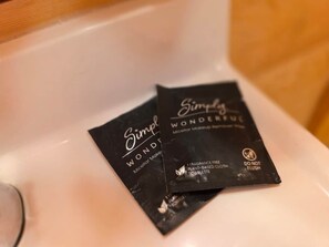Two black toiletry packets labeled 'Simply Wonderfull' on a white sink. - 7R Guest Ranch - Room 4 (Deluxe) (Lewis and Clark County)