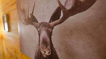 A wall-mounted deer head mounted on a wooden wall.