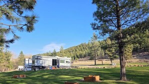 Una caravana estacionada en un césped bajo un cielo despejado.