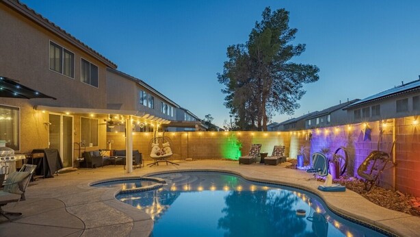 Um quintal com piscina, área de estar externa e luzes de Natal.