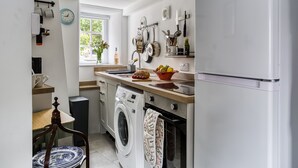 A compact kitchen with a washing machine, a sink, and a refrigerator.