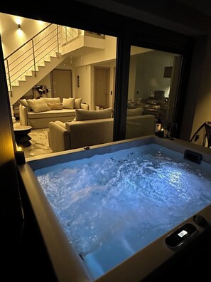 Ein Whirlpool mit Blick auf ein Wohnzimmer und eine Treppe.