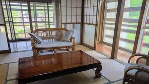 A tatami mat room with a low wooden table and a traditional Japanese chair.