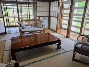 Estada en una sala amb tatamis, taula de fusta baixa i cadira japonesa tradicional.