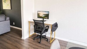 Ein moderner Arbeitsplatz mit Schreibtisch, Stuhl und Computerbildschirm.