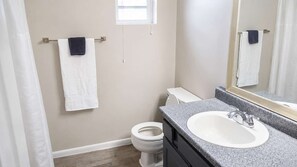 A bathroom with a toilet, sink, and towel rack. - 2BR Near Medical District - Pool & Parking (Dallas)