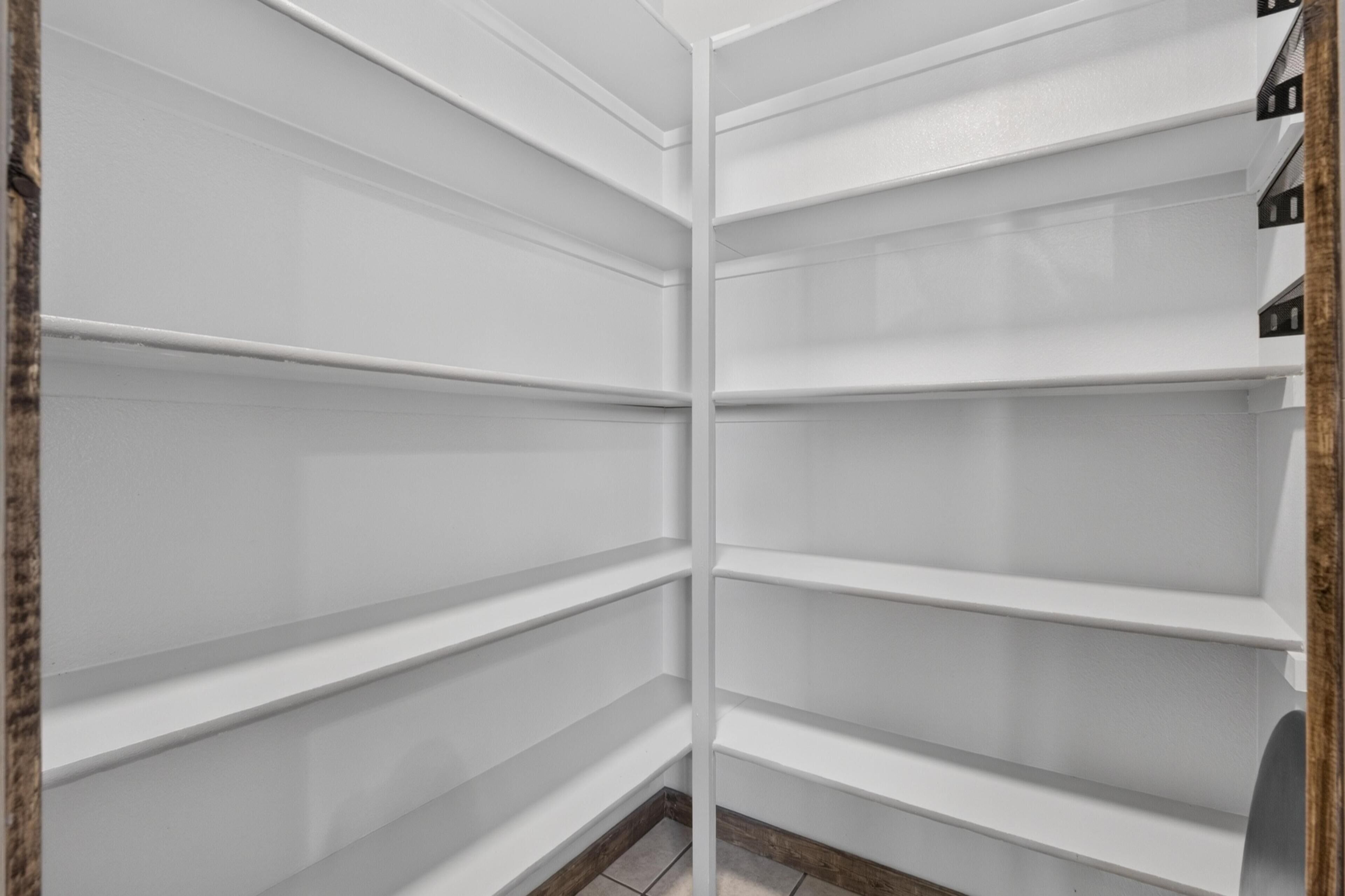 Un coin de pièce avec des étagères blanches et un plancher en bois.