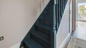 Uma escadaria com corrimãos escuros e degraus que levam a uma área aberta.
