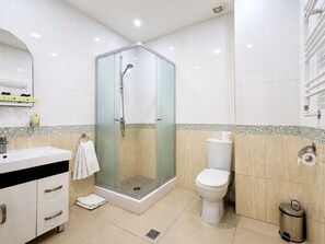 Habitación triple Deluxe | Baño | Ducha, artículos de higiene personal gratuitos y secador de pelo