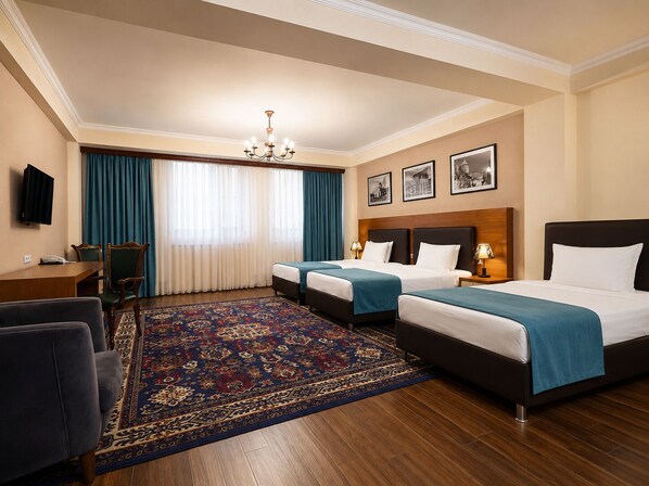 Een hotelkamer met twee bedden, een bureau, een stoel, een televisie en een kroonluchter.