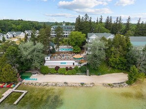 Un complexe hôtelier doté d’une piscine, d’une plage et de plusieurs bâtiments entourés d’arbres.