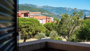 Ein Balkon mit Blick auf Häuser, Bäume und Berge.