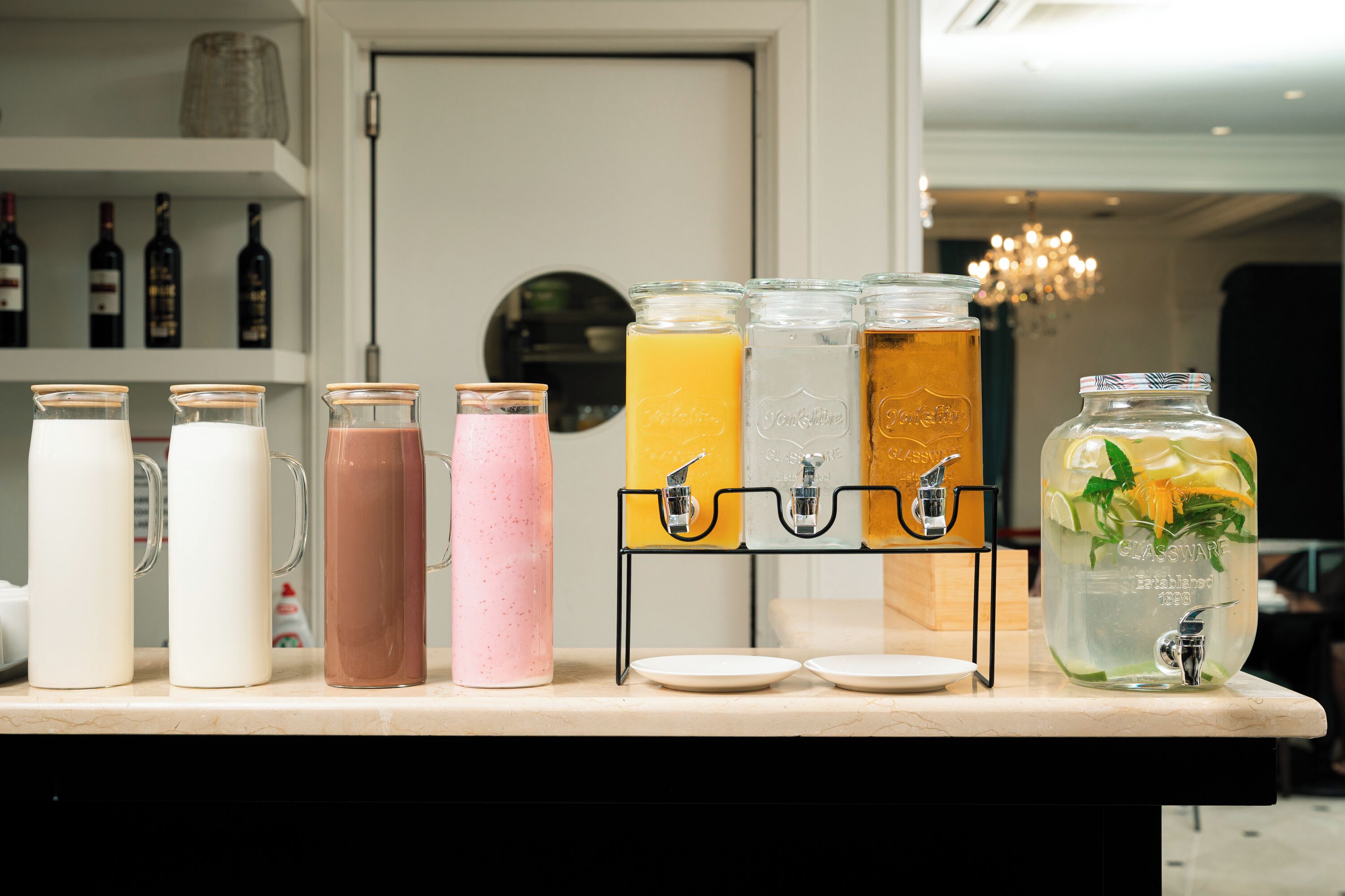 En dryckesstation med olika typer av dryckesautomater och en stor glasburk fylld med en dryck.