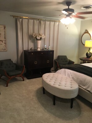 A bedroom with a bed, two armchairs, a dresser, a ceiling fan, and a lamp. - FULLY FURNISHED 4 bed 3 bath, bills paid, internet, washer/dryer, maid service (Vernon)