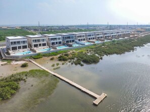 A modern hotel with multiple buildings, a dock, and a water body. - 4,000 SF Waterfront Home w/ Pool, Sleeps 22 (Port Isabel)