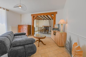 A living room with a sofa, a wooden cabinet, a TV, and a table.