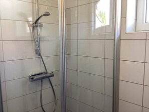 A glass-enclosed shower with a handheld showerhead and a handheld control. - 4 Person Holiday Home in Stromstad (Stromstad)