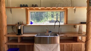 A compact kitchen with a window, a sink, and a coffee maker.