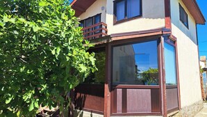 Ein Gebäude mit Balkon, Fenster und Baum.
