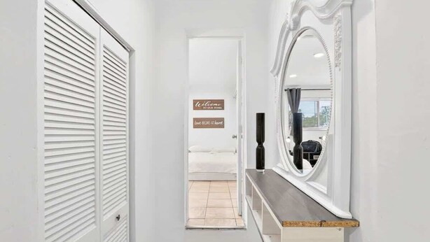 A hallway with a white door, a mirror, and a sign that reads 'Welcome to our home.' - Private 1BR Near Miami Airport with Free Parking (Hialeah)
