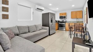 A modern kitchen with a refrigerator, microwave, oven, and dining area with chairs and a table. - Private 1BR Near Miami Airport with Free Parking (Hialeah)