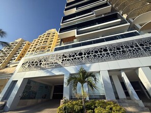Un bâtiment moderne doté d’une entrée centrale, de plusieurs étages et d’une façade distinctive à motifs perforés.