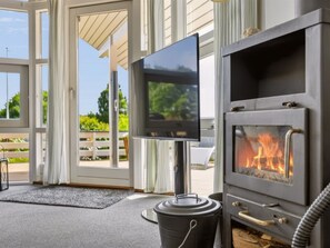 Een modern interieur met een open haard, een televisie en uitzicht op de omgeving.
